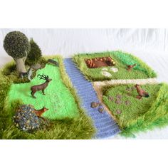 a knitted blanket with animals and trees on it