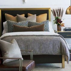 a bedroom with a bed, two chairs and a clock on the wall above it