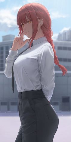 a woman with long red hair wearing a white shirt and black pants standing in front of a building