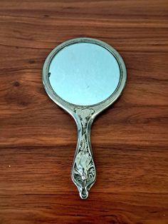 a mirror sitting on top of a wooden table next to a brown wall and floor