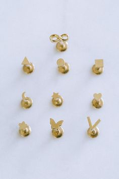 six pairs of gold ear studs on white background