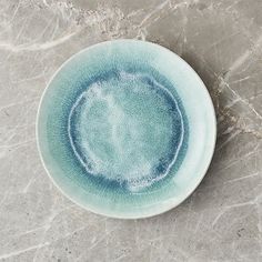 a green bowl sitting on top of a marble counter