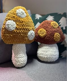 two crocheted mushrooms sitting on top of a couch