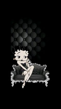 a woman sitting on top of a couch in front of a black wall with bubbles