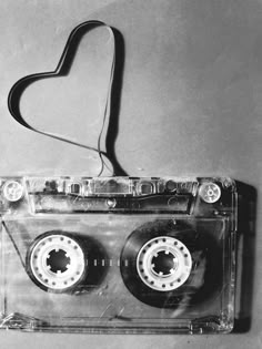 an old fashioned cassette tape recorder with a heart shaped object hanging from it's side