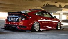 the rear end of a red car parked in a parking garage