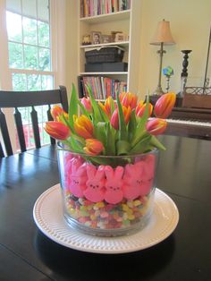 a vase filled with candy and flowers on top of a table