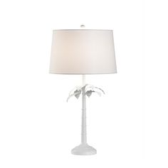 a table lamp with a white shade on the top and palm trees on the bottom