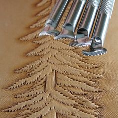 a table topped with metal utensils on top of a wooden table covered in fabric