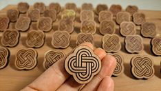 a hand holding a wooden stamp with an intricate design on it