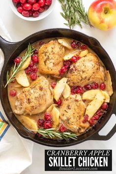 cranberry apple skillet chicken in a cast iron skillet with apples and rosemary