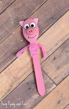 a pink paper mache with eyes and nose sitting on top of a wooden floor