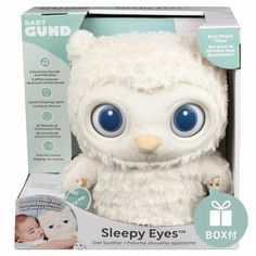 a white stuffed animal with blue eyes in a box