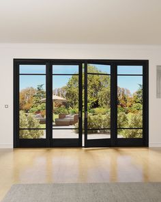 an empty room with sliding glass doors leading to a garden