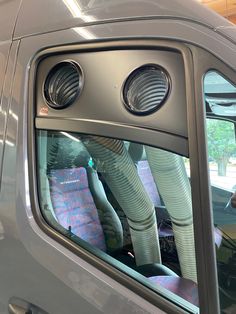 the inside of a vehicle with pipes sticking out of it's side door window