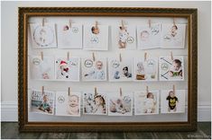 a wooden frame with pictures hanging on clothes pins and photos pinned to the pegs