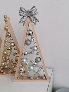 two wooden christmas trees with ornaments on them