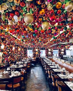 a restaurant decorated for christmas with ornaments hanging from the ceiling and tables in front of them