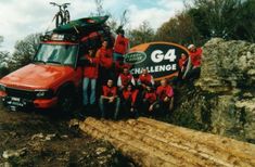 a group of people in red shirts standing next to a truck