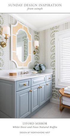 a bathroom with blue cabinets and white counter tops next to a large mirror on the wall