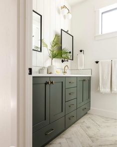 a bathroom with green cabinets and white walls