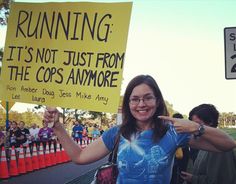 a woman holding up a sign at a race