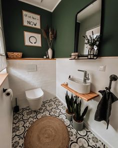 a white toilet sitting next to a sink in a bathroom