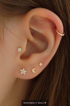 an ear with three stars and two moon piercings on it's sides, one is