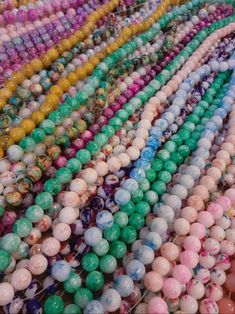 there are many different colored beads on display