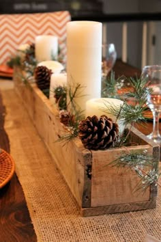 the table is decorated with pine cones and candles