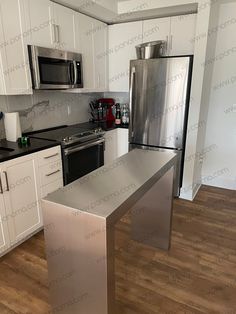 an empty kitchen with stainless steel appliances and white cabinets in the back drop off area