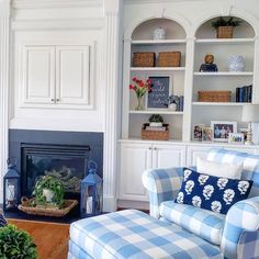 a living room filled with furniture and a fire place in front of a book shelf