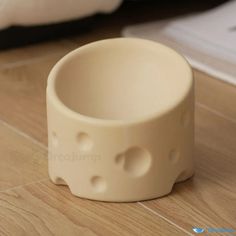 a small white bowl sitting on top of a wooden floor