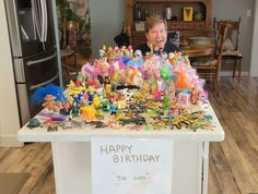 a woman standing in front of a counter filled with plastic figurines and toys