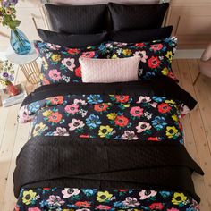 a bed with black and pink flowers on it