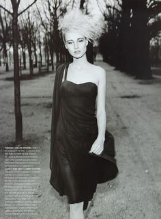 black and white photograph of a woman in a dress with her hair blowing in the wind