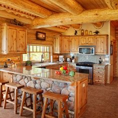 a large kitchen with wooden cabinets and granite counter tops, along with an island in the middle