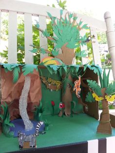 an outdoor area with paper cut out animals and trees