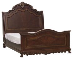 an ornate wooden bed frame with white sheets