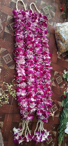 purple and white flowers are laid out on the floor