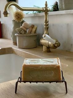 a soap bar sitting on top of a wooden counter next to a faucet