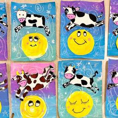 four square paintings with cows and smiley faces on them, all painted in different colors