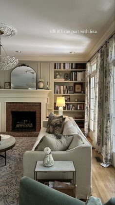 a living room filled with furniture and a fire place under a chandelier in front of a fireplace