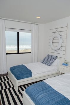 two beds in a room with black and white checkered flooring on the walls