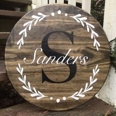 a wooden sign with the letter s on it that says sanders in white lettering