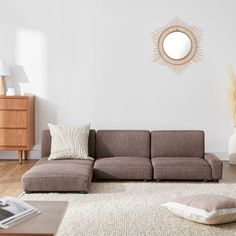 a living room with a brown couch and white rug