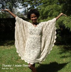 a woman is standing in the grass with her arms spread out and she wears a white crocheted dress