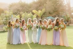 a group of women standing next to each other on top of a lush green field