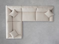 an upholstered couch with pillows on the back and sides, viewed from above