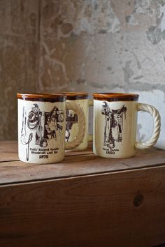 two coffee mugs sitting on top of a wooden table